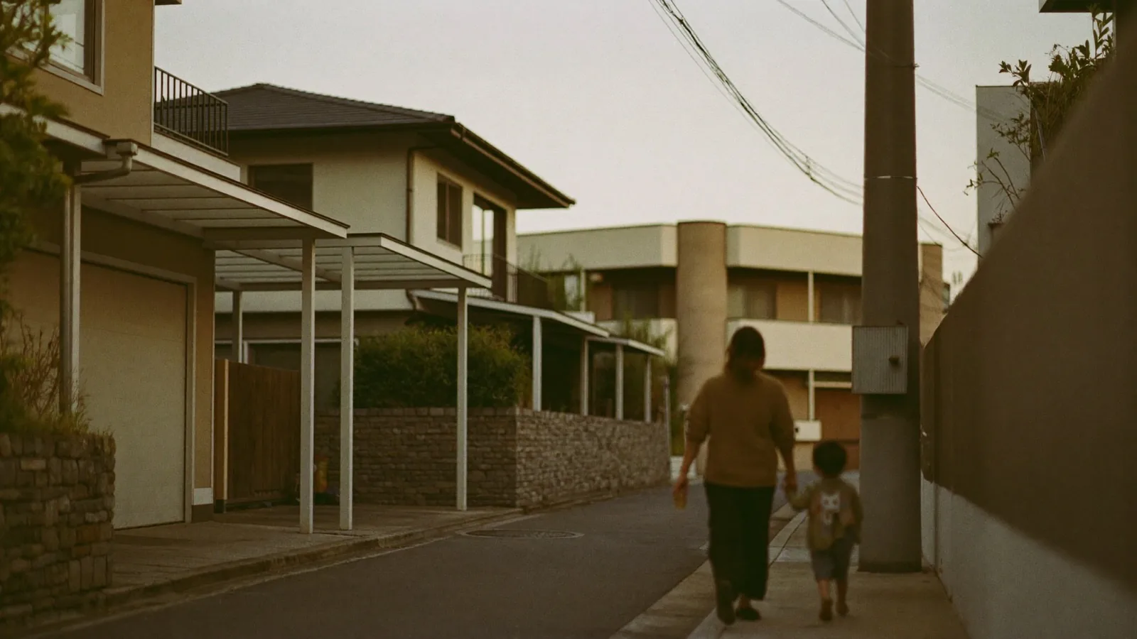夕方の住宅街を歩く親子の後ろ姿