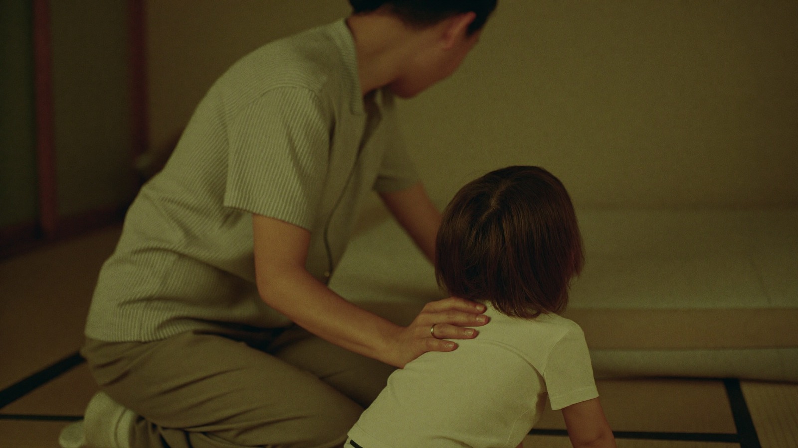 寝る前に子の背に手を添える親