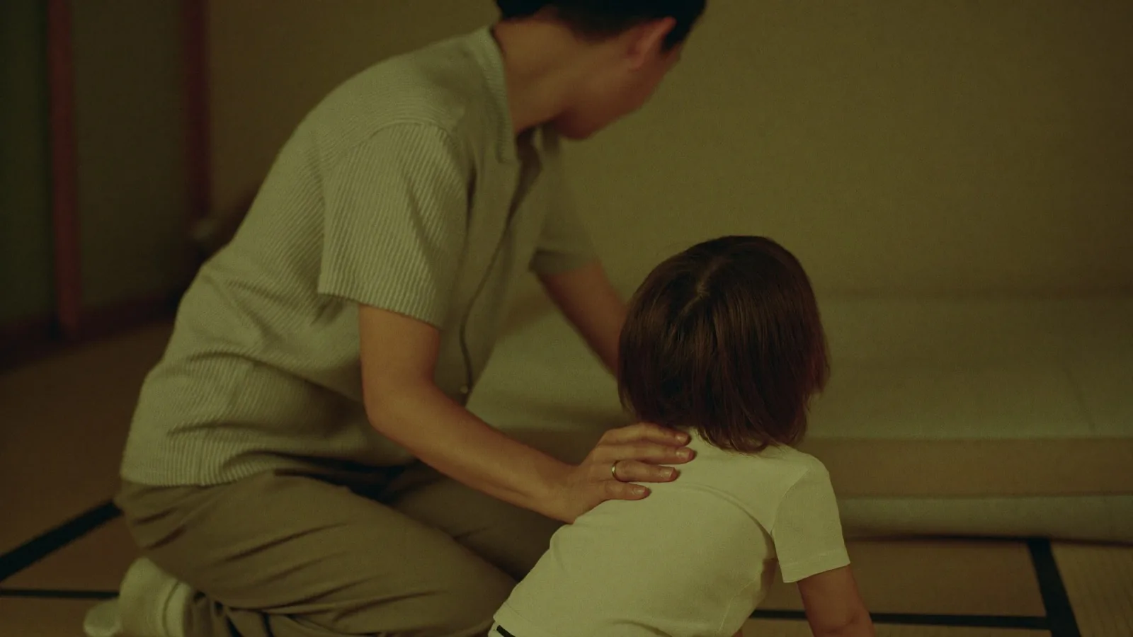 寝る前に子の背に手を添える親