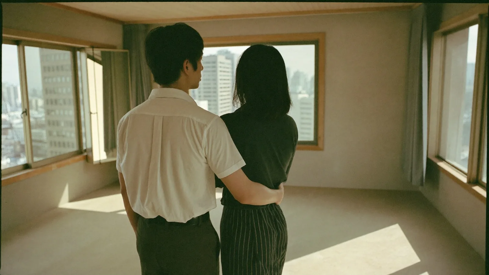 空室で外を眺める夫婦の後ろ姿